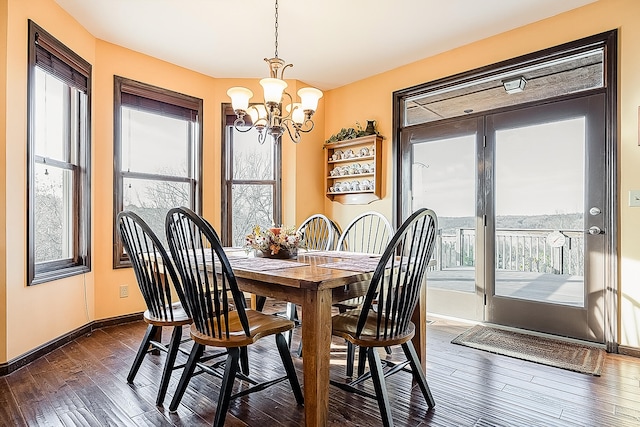 dining room with dark hardwood / wood-style flooring and a notable chandelier