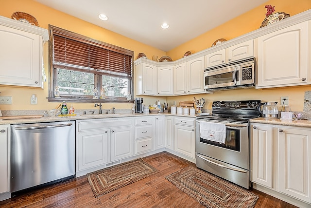 kitchen with white cabinets, stainless steel appliances, dark hardwood / wood-style floors, and sink