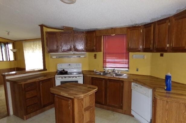 kitchen with a center island, a textured ceiling, sink, extractor fan, and white appliances