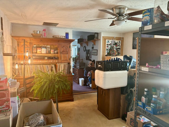 living room with ceiling fan and a textured ceiling