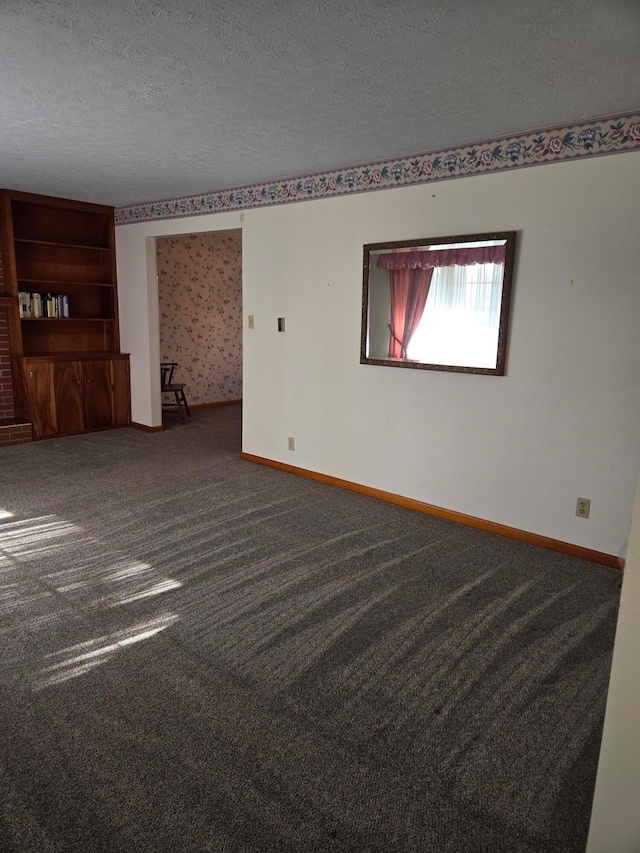 unfurnished room with carpet and a textured ceiling