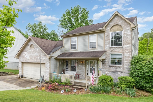 view of property featuring a front yard, a porch, and a garage