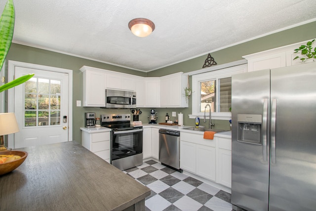 kitchen with white cabinets, plenty of natural light, sink, and stainless steel appliances