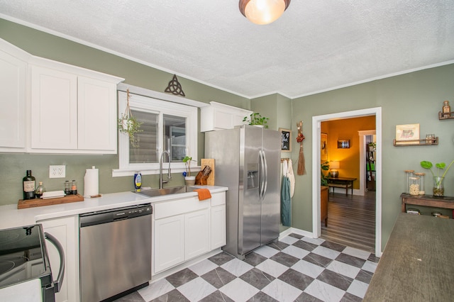 kitchen with white cabinets, a textured ceiling, appliances with stainless steel finishes, and light hardwood / wood-style flooring