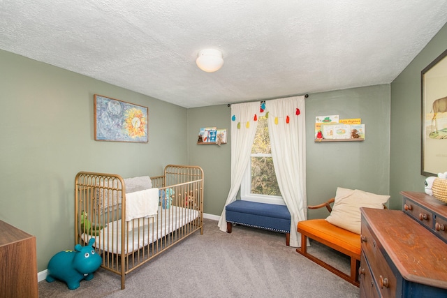 carpeted bedroom featuring a crib and a textured ceiling