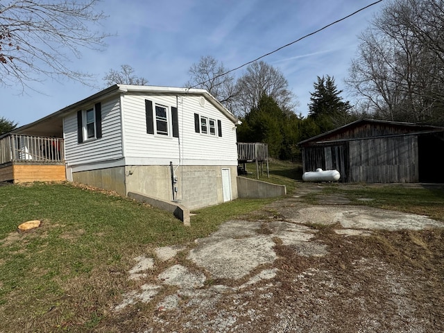 view of side of home with a lawn and a deck