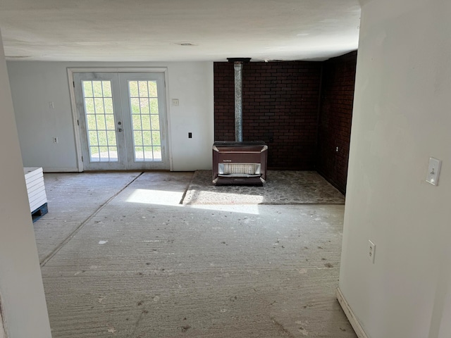 unfurnished living room with a wood stove and french doors