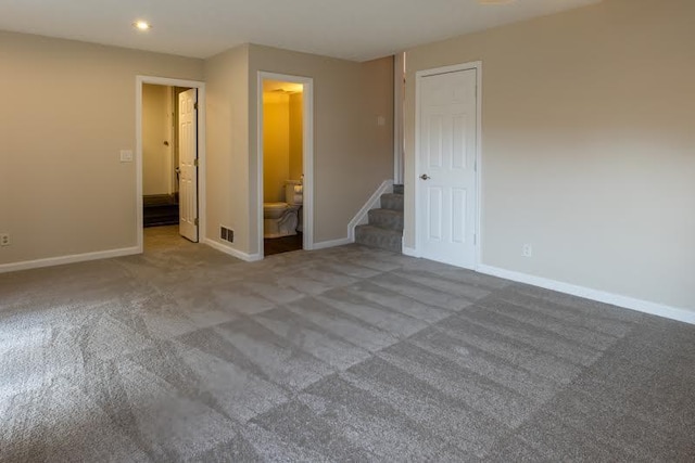 carpeted spare room with recessed lighting, visible vents, baseboards, and stairs