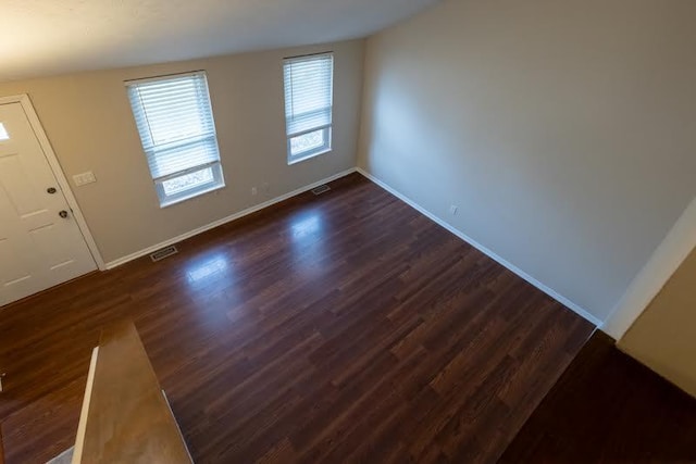 foyer entrance with baseboards, visible vents, and dark wood-type flooring