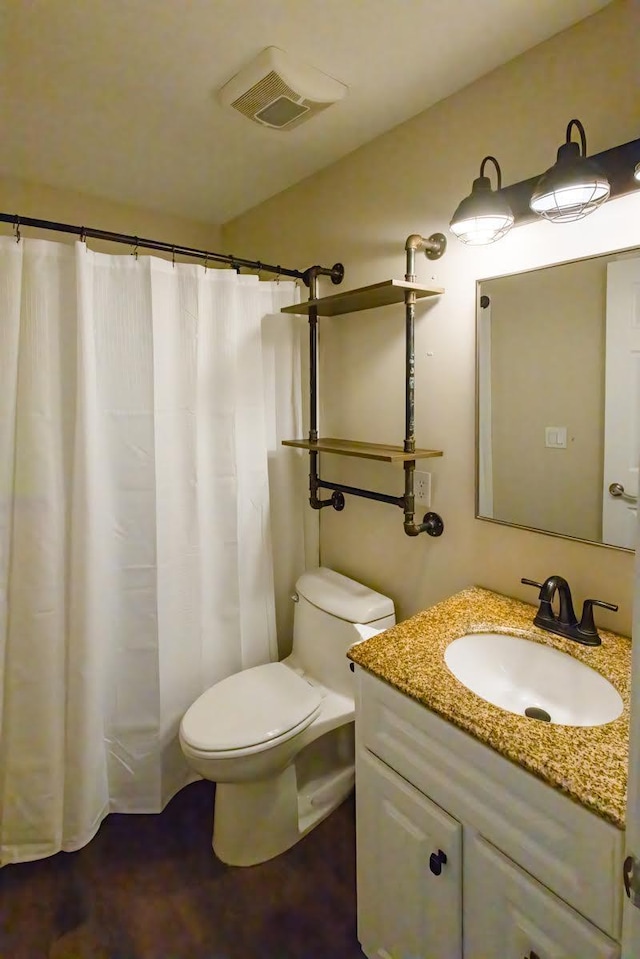 bathroom featuring visible vents, vanity, and toilet