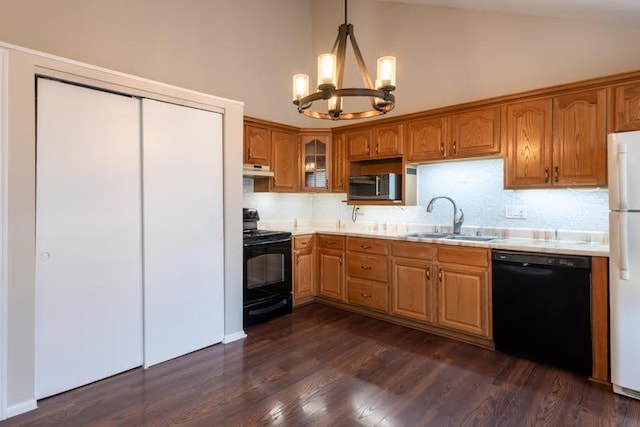 kitchen with light countertops, an inviting chandelier, a sink, under cabinet range hood, and black appliances