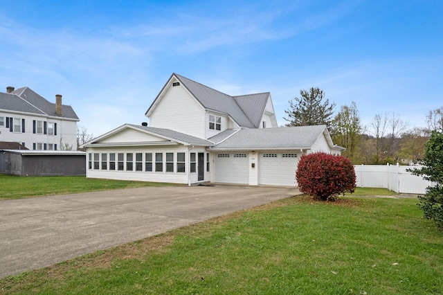 view of front facade featuring a front yard, a garage, and a sunroom