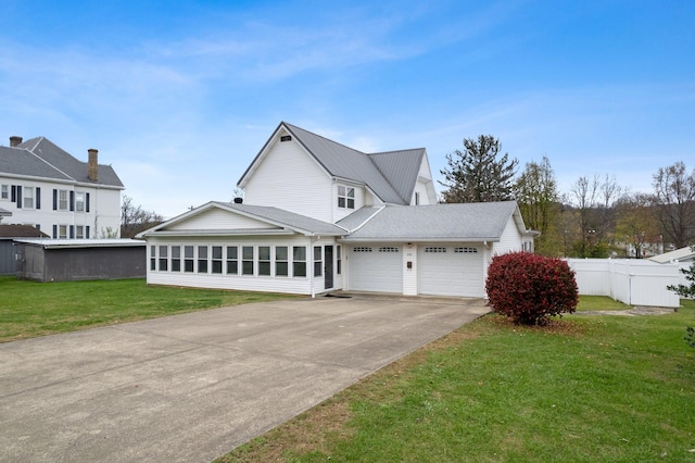 view of front of house featuring a sunroom, a garage, and a front lawn