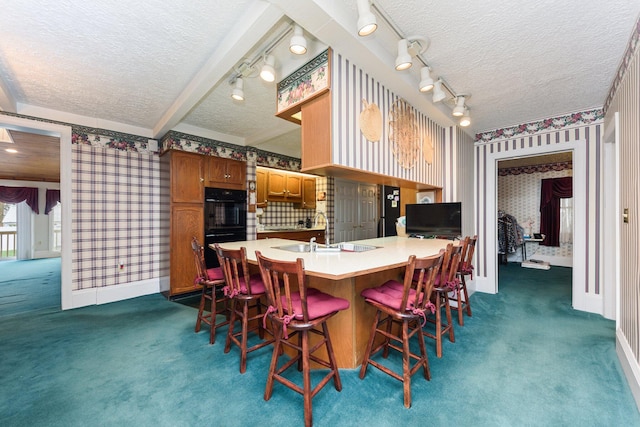 carpeted dining area featuring sink and a textured ceiling