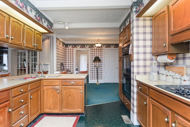 kitchen featuring kitchen peninsula, a textured ceiling, black appliances, dark colored carpet, and sink