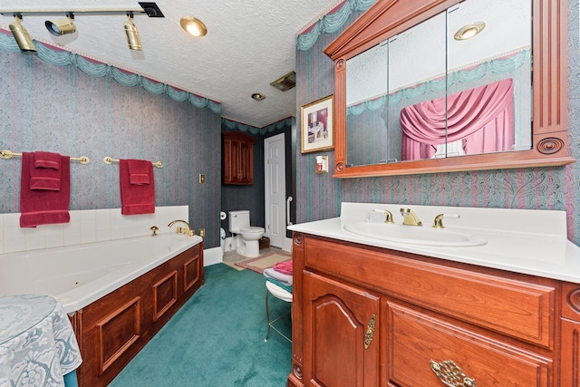 bathroom featuring a textured ceiling, vanity, toilet, and a tub