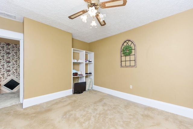 carpeted empty room featuring a textured ceiling and ceiling fan