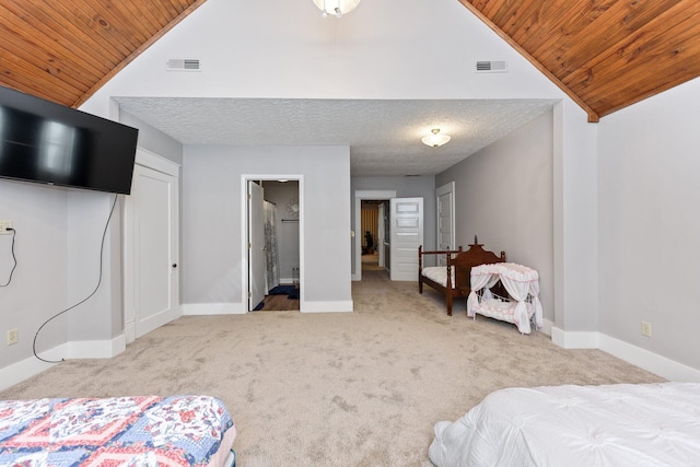 bedroom with ensuite bath, light carpet, wood ceiling, and vaulted ceiling