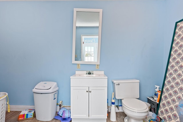 bathroom with wood-type flooring, vanity, and toilet