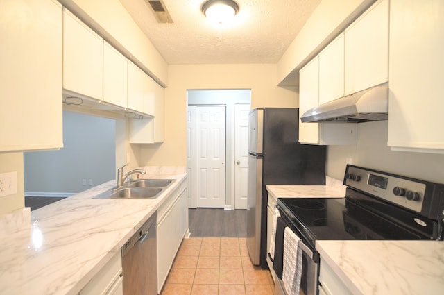 kitchen with white cabinets, a textured ceiling, stainless steel appliances, and sink