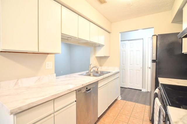 kitchen featuring dishwasher, sink, light hardwood / wood-style flooring, a textured ceiling, and kitchen peninsula