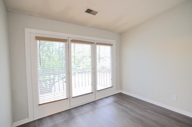 spare room featuring dark hardwood / wood-style flooring and plenty of natural light