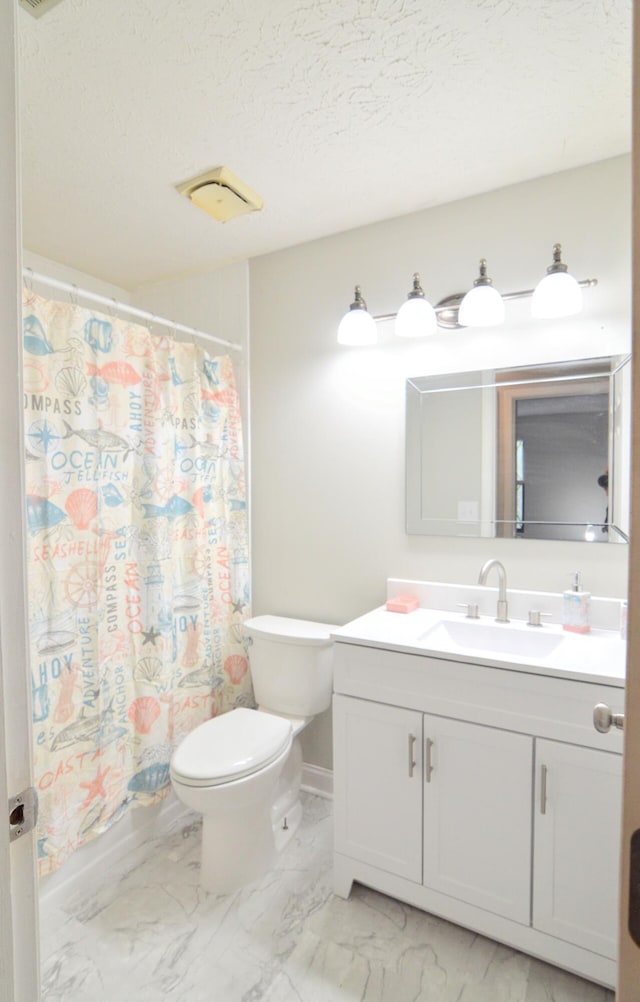 bathroom with vanity, toilet, and a textured ceiling