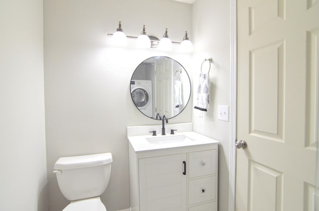 bathroom featuring vanity, toilet, and washer / clothes dryer