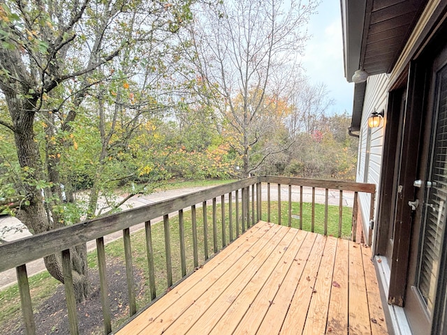 wooden terrace featuring a lawn