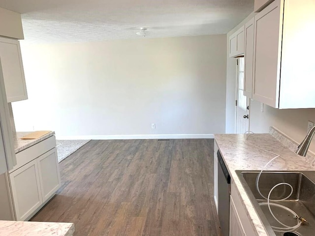 kitchen featuring white cabinetry, sink, dark hardwood / wood-style flooring, stainless steel dishwasher, and a textured ceiling