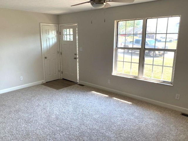 carpeted foyer entrance with ceiling fan