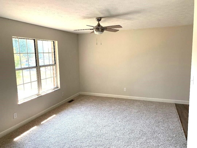 carpeted spare room featuring ceiling fan and a textured ceiling