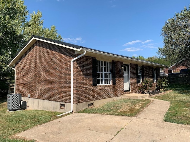 ranch-style house featuring central air condition unit and a front lawn