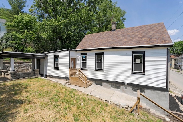 rear view of house featuring a lawn