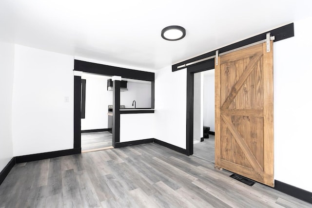 spare room featuring hardwood / wood-style floors and a barn door