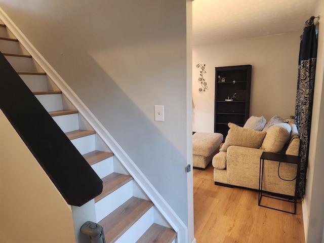 stairs featuring hardwood / wood-style floors