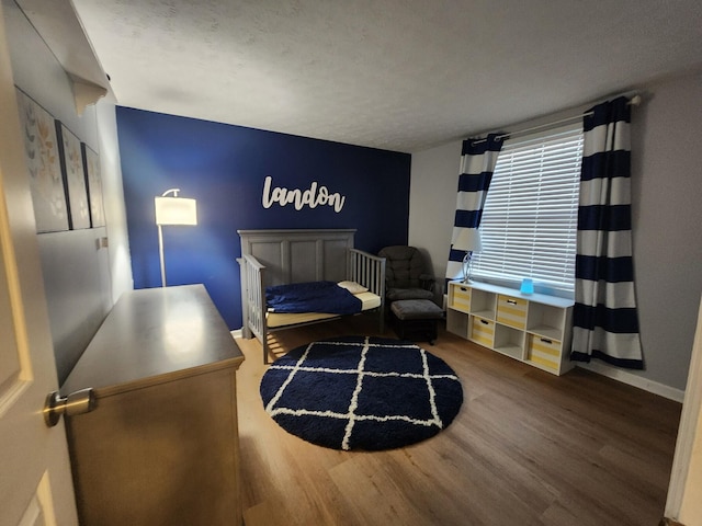 bedroom featuring a textured ceiling and wood-type flooring