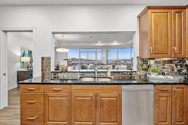 kitchen with sink, crown molding, and dark stone countertops