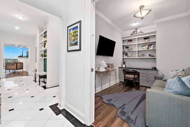 living room featuring built in shelves, light hardwood / wood-style floors, and crown molding