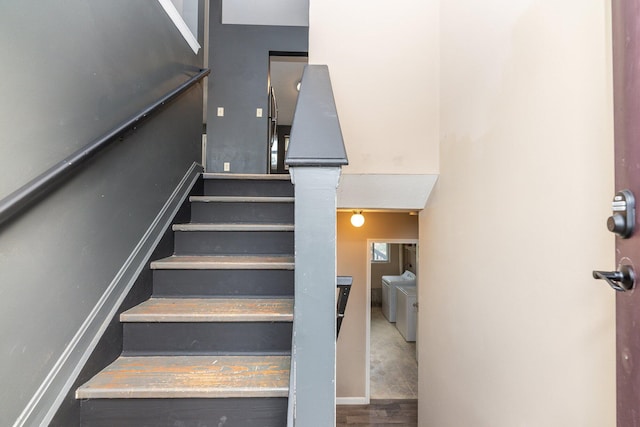 stairs with hardwood / wood-style flooring and independent washer and dryer