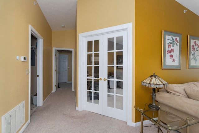 hall with light carpet, french doors, and lofted ceiling