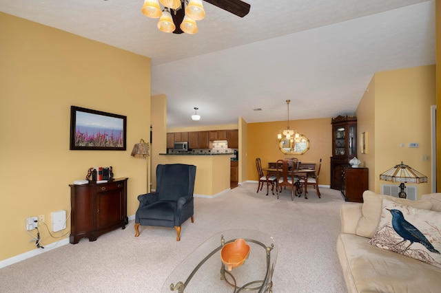 carpeted living room with ceiling fan with notable chandelier