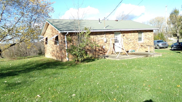 back of property with a lawn and a patio area