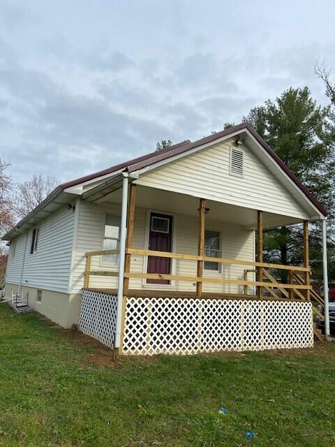 exterior space with covered porch and a front yard