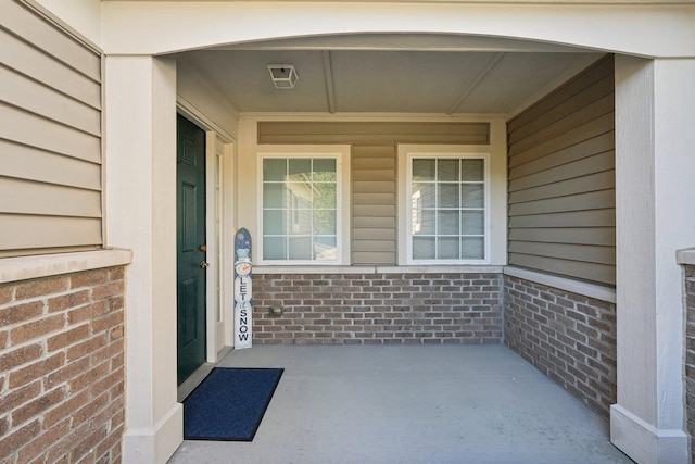 doorway to property featuring brick siding