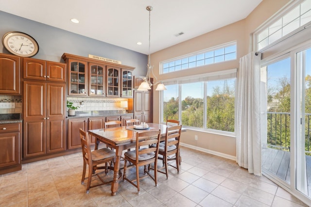 dining room featuring light tile patterned floors, plenty of natural light, visible vents, and baseboards