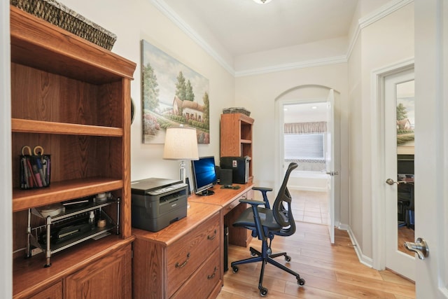 home office featuring light wood-style floors, baseboards, and arched walkways