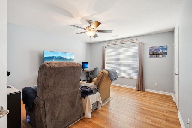 home office featuring light wood finished floors, ceiling fan, and baseboards