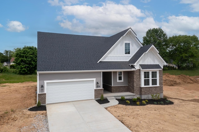 view of front facade with brick siding, board and batten siding, driveway, and an attached garage