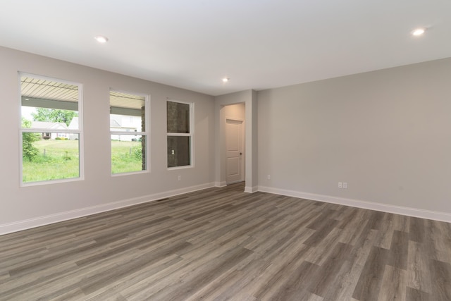 empty room with wood finished floors, recessed lighting, and baseboards